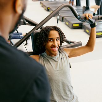 A teenage boy working out at the gym with an instructor A teenage boy working out at the gym with an instructor