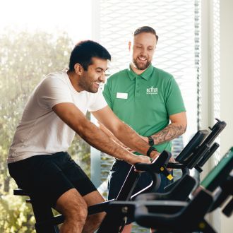 man with trainer on bike