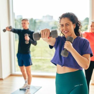 A couple of people in a fitness class using handweights