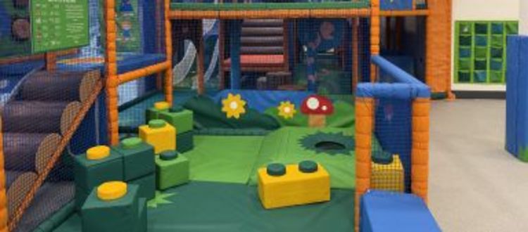 bright soft play with foam shapes and enclosed by netting
