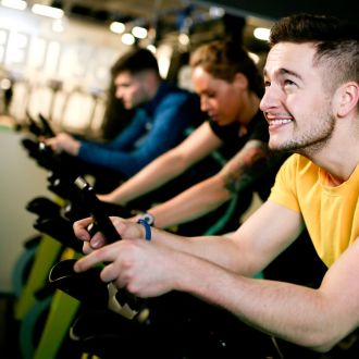 group on exercise bikes smiling