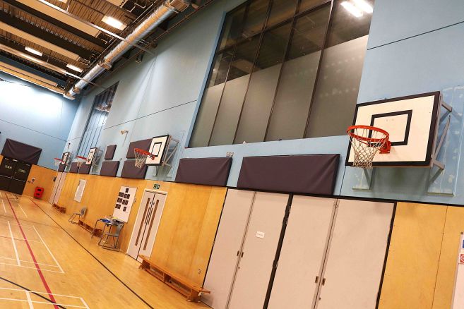 Sports hall showing basketball hoops and industrial roofing