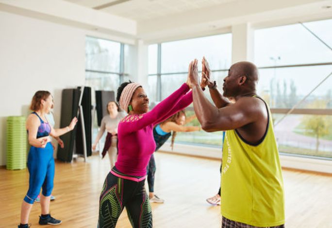 Male and female members celebrating in a fitness studio