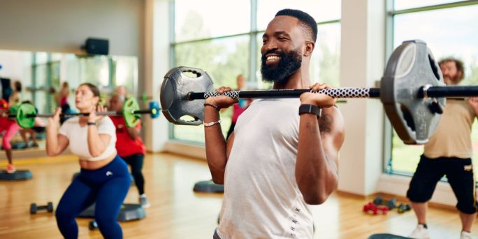 Someone working out with a barbell in a fitness class