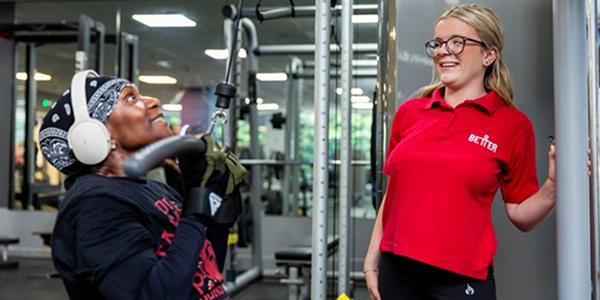 A woman working out at the gym with a female instructor