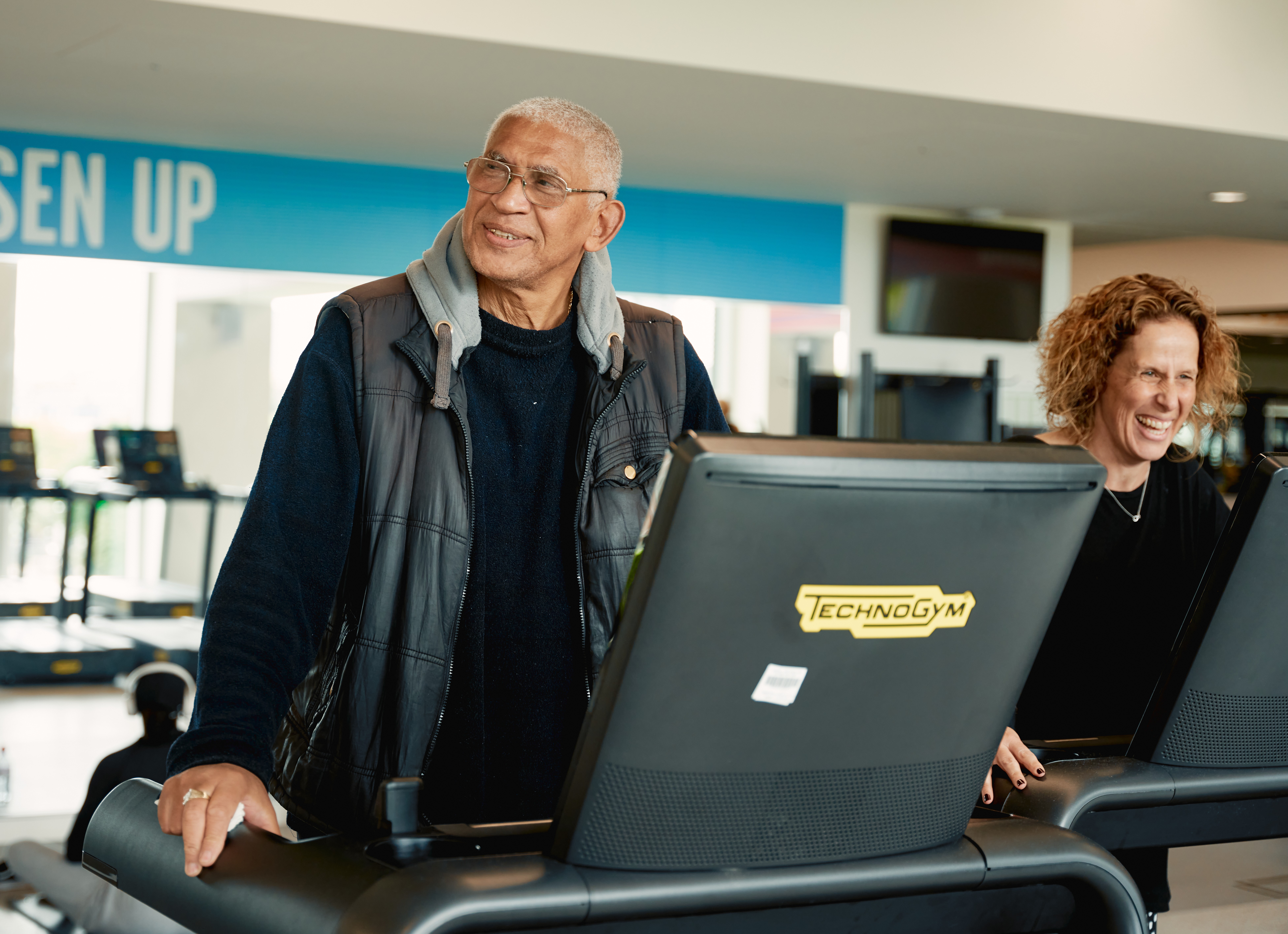 image shows and older man and younger woman on treadmils