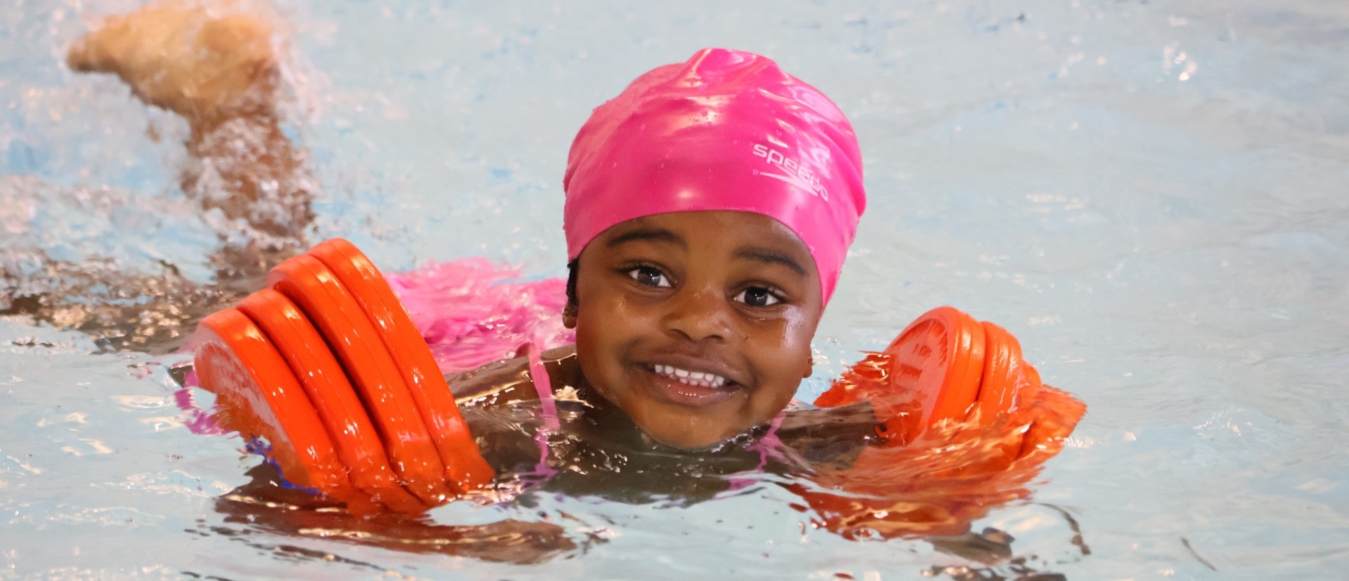 Young girl wearing armbands in the water