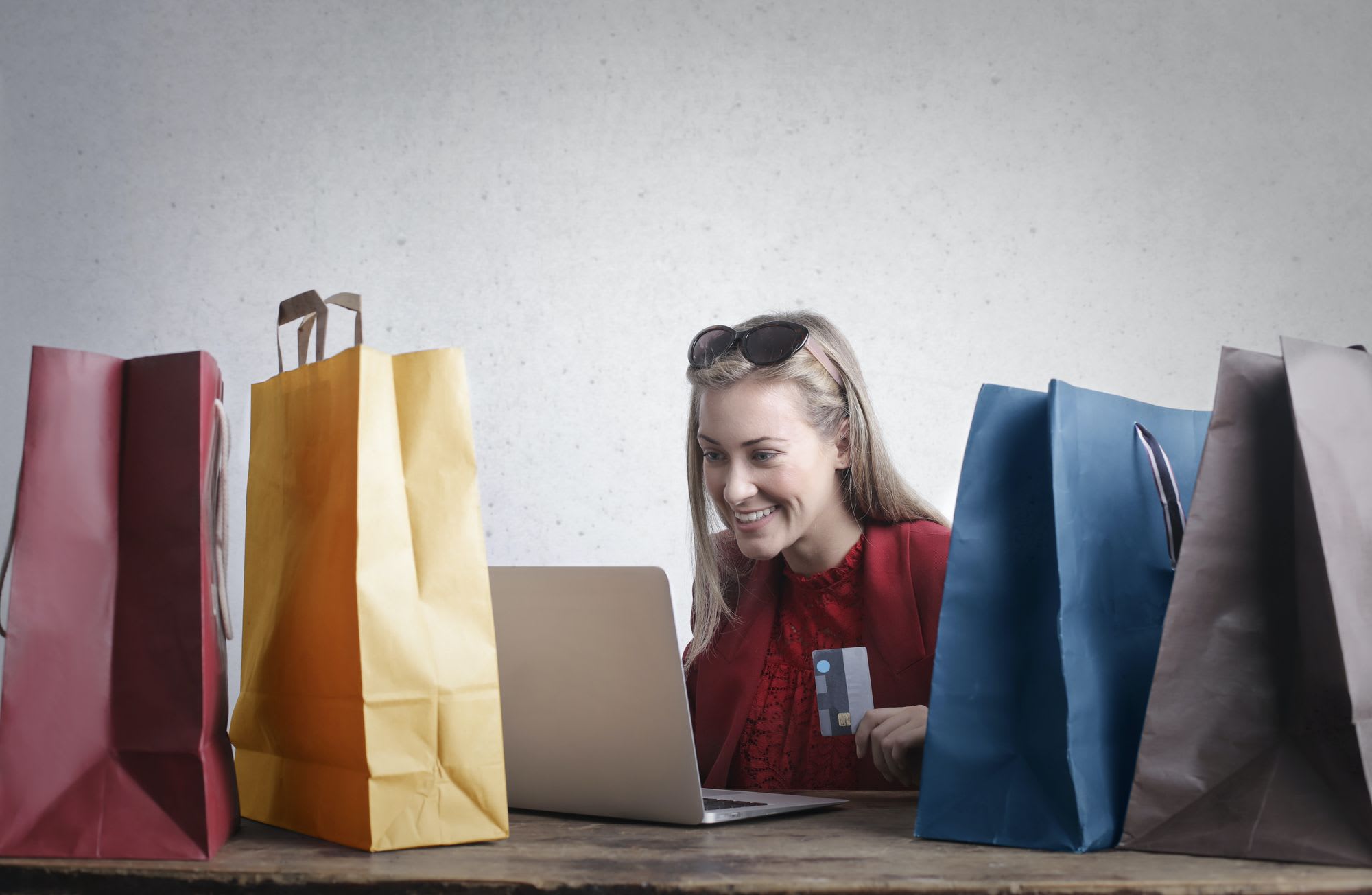 A lady smiling using a laptop to shop. The image represents a user friendly site without needing an ecommerce developer