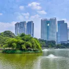 Perdana Botanical Gardens with its lake and skyscraper backdrop during the day