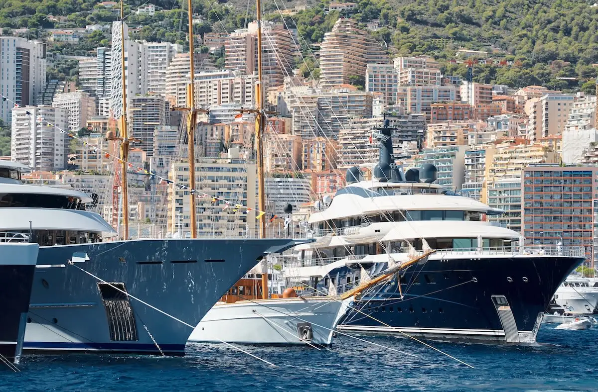 yachts in Monaco harbor with buildings behind them 