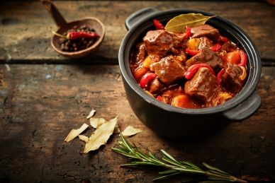 A Pot of Hungarian Goulash Stew with a Sprig of Rosemary on the Side