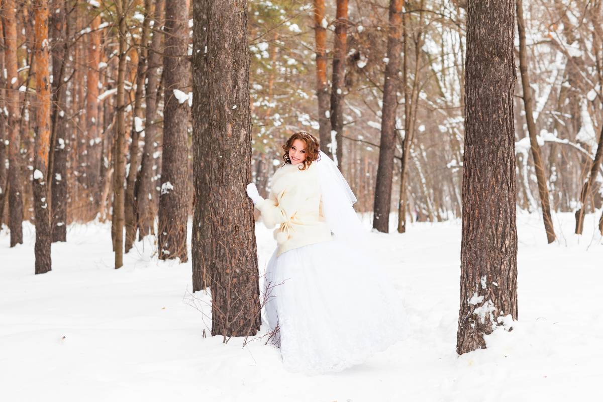 Mit einer schönen warmen Jacke und weißen Handschuhen ist die Braut auch im Winter schön angezogen