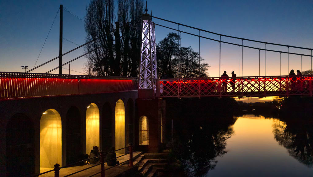 View at dusk of four people on the Daley's bridge