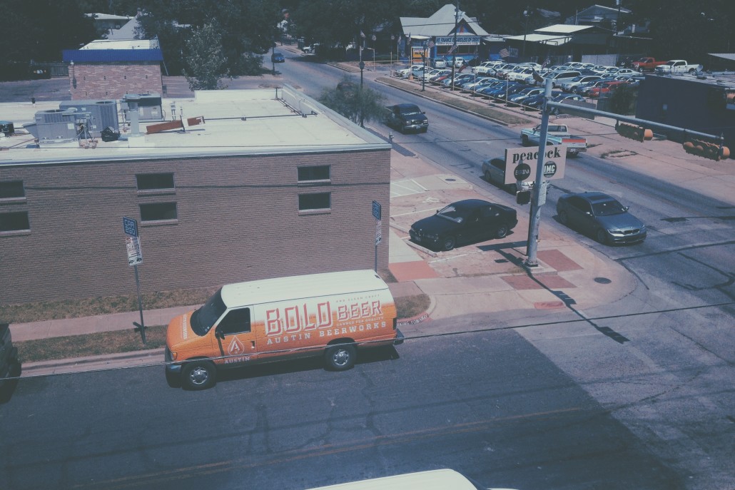 A beer van marked Bold Beer pulled up next to a low square building