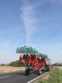 Packers - Kverneland Packomat compact and transported above ground level, dragged by tractor in a folded shape