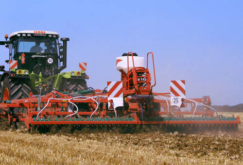 Stubble Cultivators - Kverneland-a-drill pulled by tractor operating on field