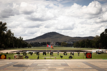 The site of the Aboriginal Tent Embassy on the lawns outside Old Parliament House. Black letters spell out the word 'Sovereignty' on a green lawn.