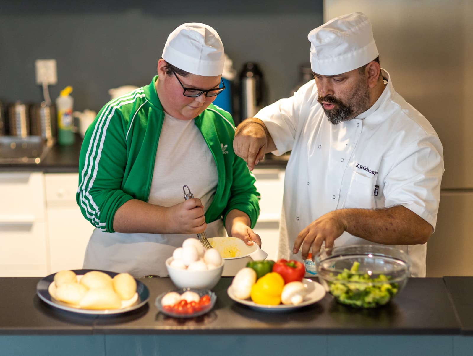 En PitStop-ungdom lager mat med en kjøkkensjef. Rundt 80 % av ungdommen som deltok i PitStops pilotprosjekt mellom 2016 og 2019 kom seg tilbake i skole, arbeid eller annen tilrettelagt aktivitet.