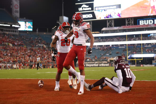 NC State Wolfpack football's C.J. Riley celebrates a touchdown catch against Texas A&M in the Gator Bowl.