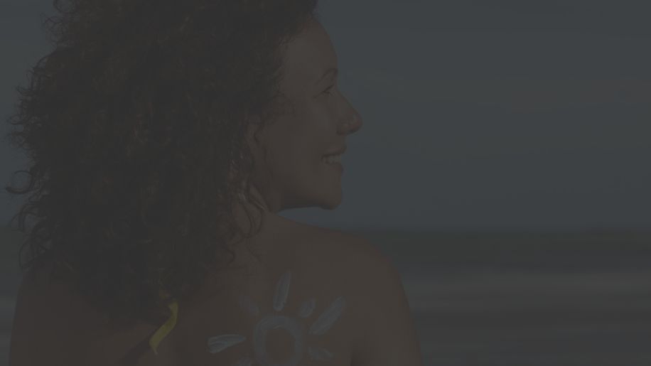 mature woman at beach with sunscreen