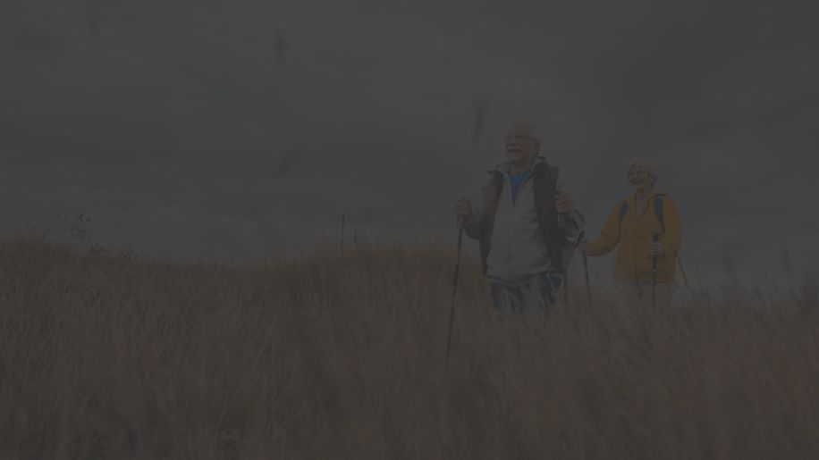 senior couple nordic walking in a field
