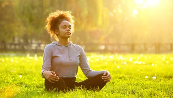 woman meditating in grass