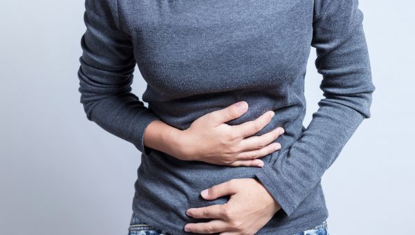 woman holding stomach in pain