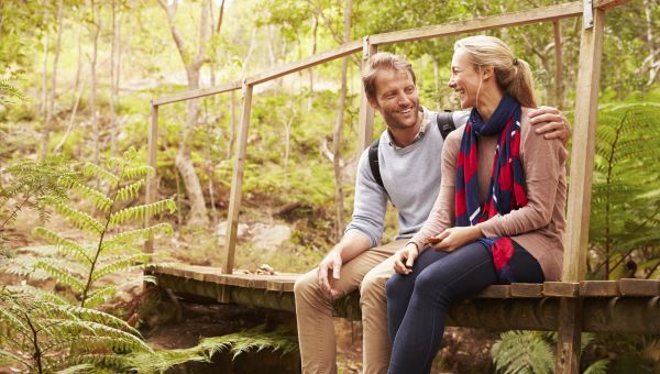 middle aged couple sitting on a walking bridge