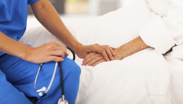 nurse holding patient's hand