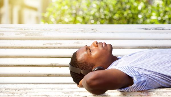 man on a bench resting and listening to music