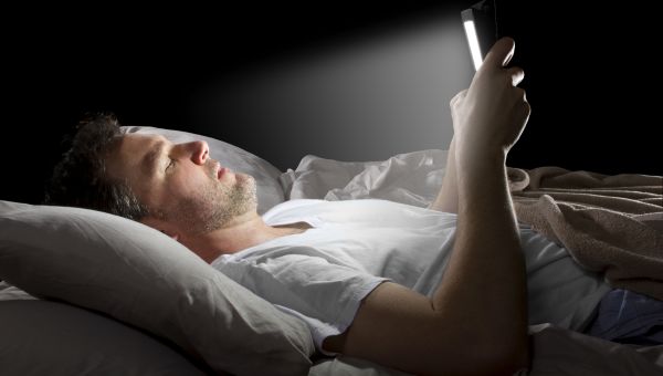 man reading in bed at night