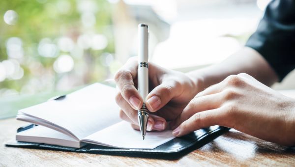 close up of woman writing her journal