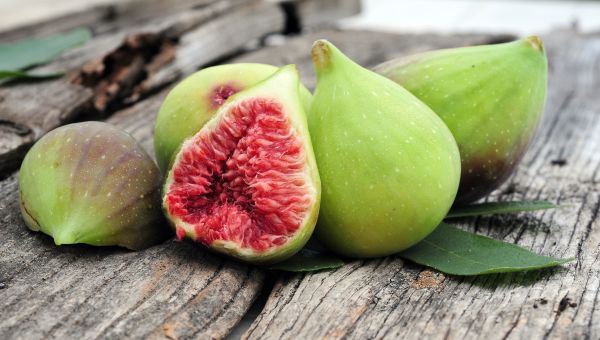 Fig showing green skin outside and red fruit inside