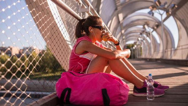 woman, apple, workout clothes, gym bag, bridge