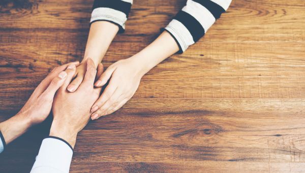 holding hands, four hands, wooden surface