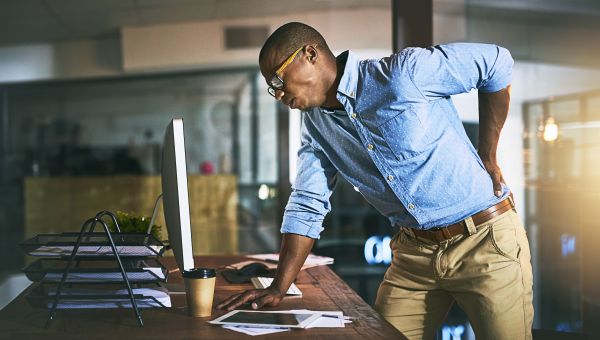 man having back pain at office