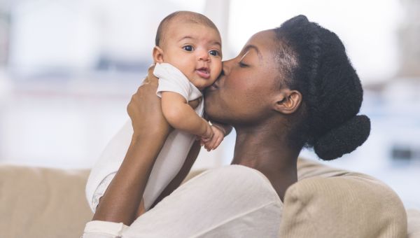 Woman kissing her infant on the cheek