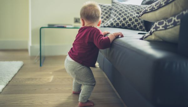 Infant holding onto couch