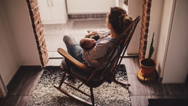 Someone holding newborn in rocking chair