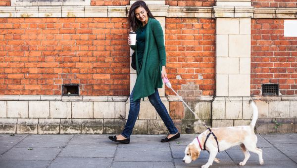 woman walking dog down the street