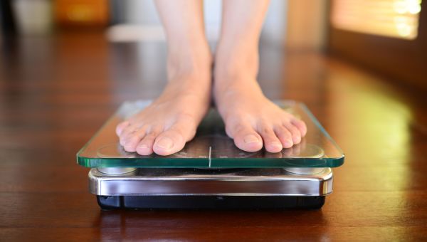 Woman standing on a weight scale