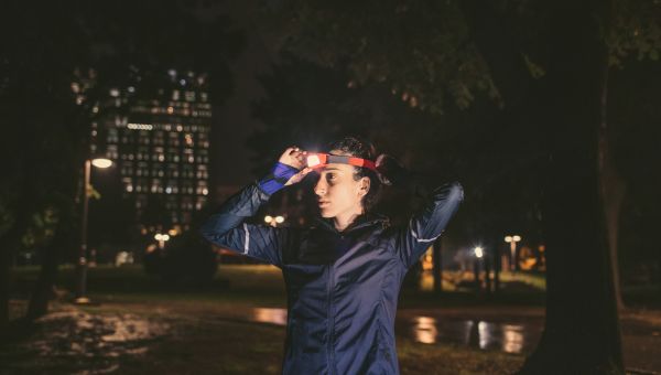 Female runner putting on headlamp