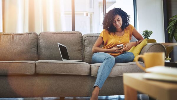 Young woman texting on couch