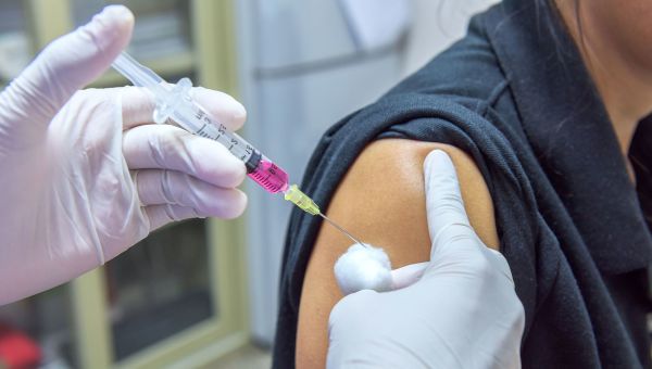 Nurse administering vaccine to patient