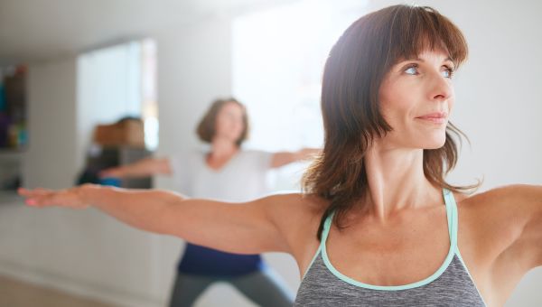 two middle aged people doing yoga poses