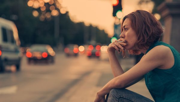 Woman sitting outside smoking.