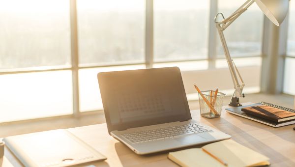 Laptop and notebook on wooden desk