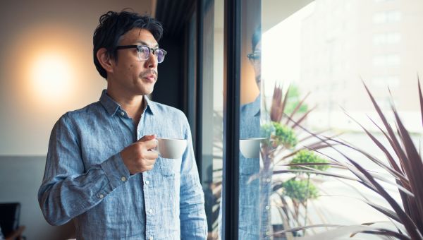Man sipping coffee by the window