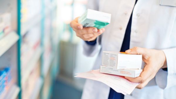 Pharmacist looking over drug packaging.