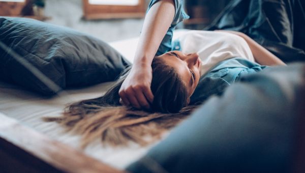 person lying in bed seemingly debilitated